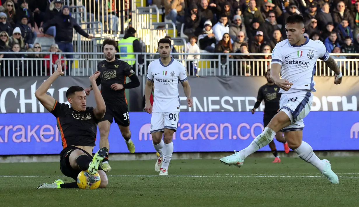 Pemain Venezia, Jay Idzes (kiri) menghentikan bola tendangan pemain Inter Milan, Lautaro Martinez pada laga lanjutan Liga Italia 2024/2025 di Pier Luigi Penzo Stadium, Venice, Minggu (12/01/2025) malam WIB. (AP Photo/LaPresse/Paola Garbuio)