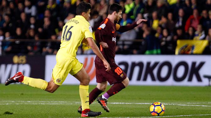 Pemain Barcelona, Lionel Messi berebut bola dengan pemain Villarreal, Rodrigo Hernandez pada jornada ke-15 La Liga di Stadion Ceramica, Minggu (10/12). Barcelona menang 2-0 usai Villarreal bermain dengan sepuluh orang di babak kedua. (AP/Alberto Saiz)