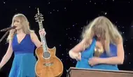 Taylor Swift terlihat sedang mengatasi masalah malfunction wardrobe di atas panggung. (TikTok @ella37980&nbsp;https://vt.tiktok.com/ZSYN3w2Co/)