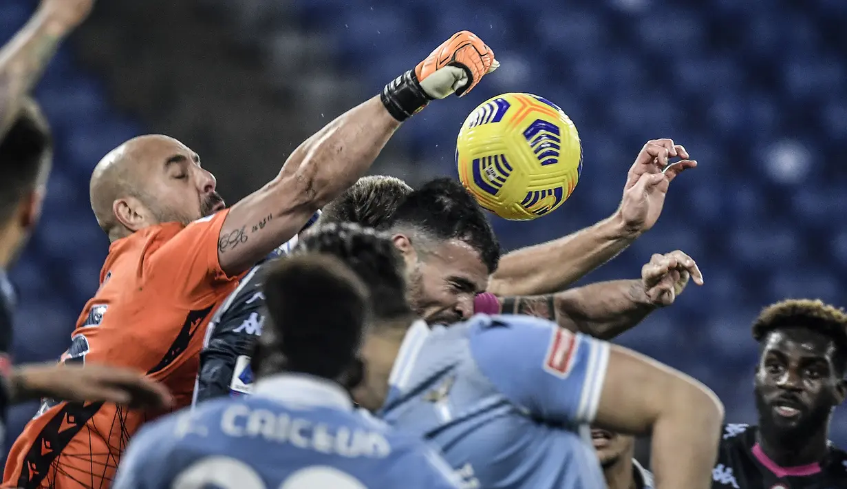 Kiper Lazio, Pepe Reina (kiri), meninju bola dari ancaman pemain Napoli dalam laga lanjutan Liga Italia Serie A 2020/21 pekan ke-13 di Olimpico Stadium, Roma, Minggu (20/12/2020). Lazio mengalahkan Napoli 2-0. (AFP/Filippo Monteforte)