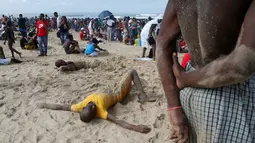Sejumlah pengunjung mengubur diri dengan pasir saat liburan awal Tahun Baru 2017 di sebuah pantai di Durban, Afrika Selatan (1/1). (REUTERS/Rogan Ward)