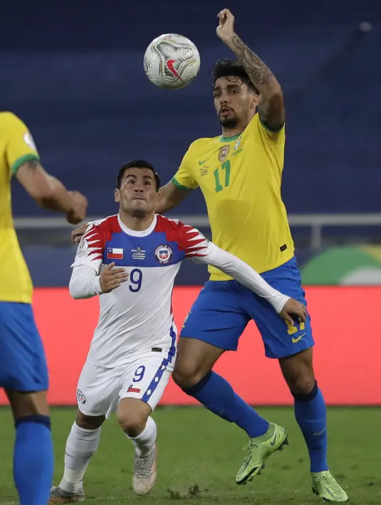 Gelandang timnas Chile, Jean Meneses berebut bola dengan gelandang Brasil, Lucas Paqueta pada perempat final Copa America 2021 di Stadion Nilton Santos, Sabtu (3/7/2021) pagi WIB. Timnas Brasil lolos ke babak semifinal Copa America 2021 berkat kemenangan 1-0 atas Chile. (AP Photo/Silvia Izquierdo)