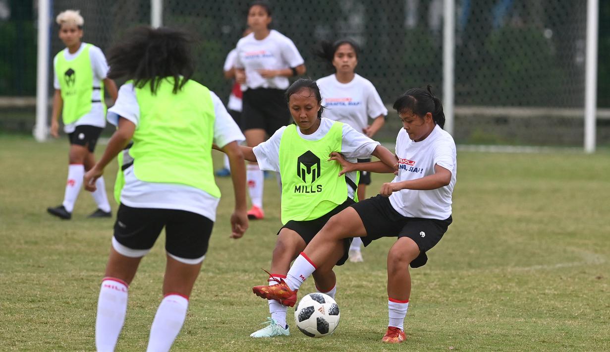 Dua pemain Timnas sepakbola putri Indonesia berebut bola dalam pertandingan internal yang menandai pembukaan pemusatan latihan (TC) proyeksi SEA Games 2021 Vietnam di Lapangan D Kompleks Gelora Bung Karno, Senayan, Jakarta, Senin (8/3/2021). (AFP/Adek Berry)
