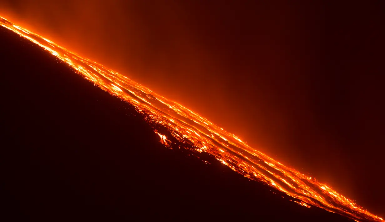 Muntahan lava panas keluar dari perut Gunung Etna saat meletus di pulau selatan Sisilia, Italia, Senin (7/12). Gunung berapi tertinggi di Eropa tersebut kembali memuntahkan abu vulkanik setelah dua tahun tidak ada aktivitas. (REUTERS/Antonio Parrinello)