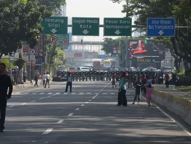 Polisi menyiapkan tameng untuk menutup jalan menuju Gedung Mahkamah Konstitusi (MK), Jakarta, Kamis (27/6/2019). Puluhan ribu personel TNI-Polri dikerahkan guna mengamankan sidang pembacaan putusan hasil sengketa pilpres 2019 serta melakukan penutupan jalan menuju Gedung MK (merdeka.com/Imam Buhori)