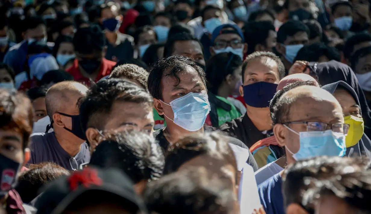 Warga menunggu dalam antrean untuk mendaftar vaksinasi virus corona COVID-19 AstraZeneca di Denpasar, Bali, Sabtu (26/6/2021). Ratusan warga terlihat antusias mengikuti vaksinasi massal tersebut. (SONY TUMBELAKA/AFP)