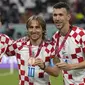 Tiga pemain Kroasia, Luka Modric (tengah), Mateo Kovacic (kiri), dan Ivan Perisic berpose dengan medali setelah meraih peringkat ketiga di Piala Dunia 2022. Ini merupakan kedua kalinya Kroasia meraih peringkat ketiga dalam perhelatan akbar empat tahunan ini, sebelumnya pada Piala Dunia 1998 Kroasia langsung menjadi tim peringkat ketiga dalam debut mereka di Piala Dunia. (AP Photo/Frank Augstein)