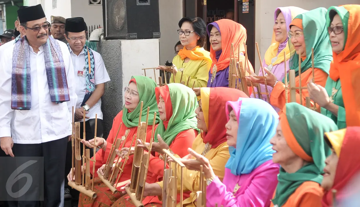 Sejumlah ibu PKK memainkan alat musik angkung saat menyambut kedatangan Wagub DKI Jakarta, Djarot Saiful Hidayat untuk meresmikan Ruang Publik Terpadu Ramah Anak (RPTRA) Pola Pinang, Pondok Labu, Jakarta Selatan, Kamis (13/10). (Liputan6.com/Yoppy Renato)