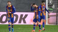 Pemain Barcelona, Lionel Messi, Sergi Roberto dan Pedri, tampak kecewa usai ditaklukkan Real Madrid pada laga Liga Spanyol di Stadion Alfredo di Stefano, Minggu (11/4/2021). Real Madrid menang dengan skor 2-1. (AFP/Javier Soriano)