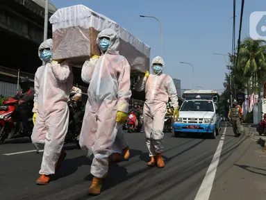 Petugas gabungan dari Kecamatan Cilandak dan Polsek Cilandak mengarak instalasi peti mati jenazah Covid-19 di kantor kecamatan Cilandak, Jakarta, Jumat (28/8/2020). Sosialisasi tersebut dilakukan untuk memberikan peringatan akan bahaya penularan virus Covid-19. (Liputan6.com/Herman Zakharia)