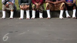 Sejumlah warga Petani Kendeng, Pati, Jawa Tengah, bersiap menyemen kakinya di depan Istana Negara, Jakarta, Senin (13/3). Aksi ini merupakan aksi yang ketiga yang dilakukan warga Kendeng. (Liputan6.com/Johan Tallo)