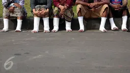 Sejumlah warga Petani Kendeng, Pati, Jawa Tengah, bersiap menyemen kakinya di depan Istana Negara, Jakarta, Senin (13/3). Aksi ini merupakan aksi yang ketiga yang dilakukan warga Kendeng. (Liputan6.com/Johan Tallo)
