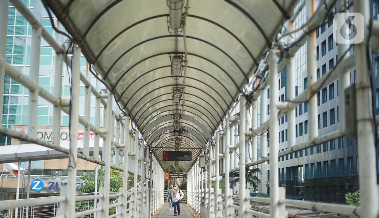 Penumpang melintasi JPO yang juga akses menuju Halte Transjakarta Karet di Jakarta, Kamis (12/11/2020). Proyek tersebut diperkirakan akan dimulai pada Desember 2020 mendatang. (Liputan6.com/Immanuel Antonius)