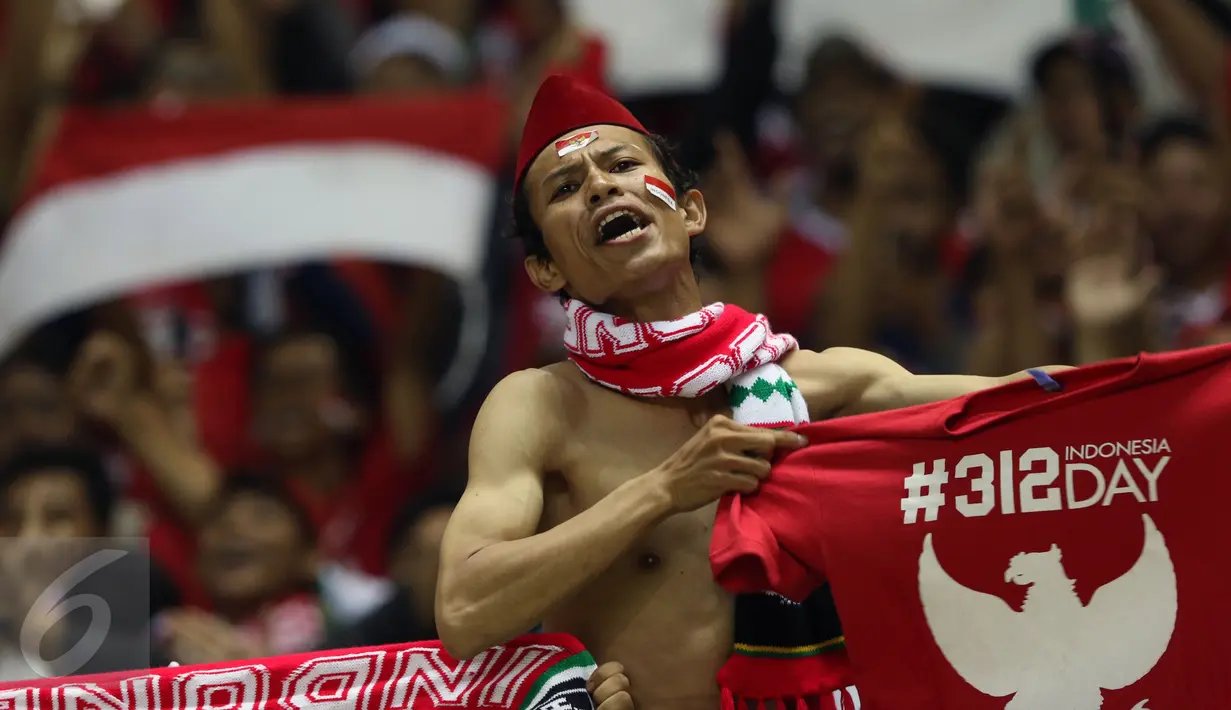 Suporter berteriak sambil membentangkan kaos jelang menyaksikan laga Timnas Indonesia melawan Vietnam pada semifinal pertama Piala AFF 2016 di Stadion Pakansari, Bogor, Sabtu (3/12). Indonesia unggul 2-1 atas Vietnam. (Liputan6.com/Helmi Fithriansyah)