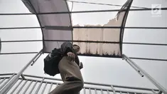 Pejalan kaki melintasi jembatan penyeberangan orang (JPO) di Jalan Yos Sudarso, Jakarta, Kamis (8/11). JPO mengalami kerusakan pada bagian atap yang jebol. (Merdeka.com/Iqbal Nugroho)