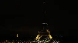 Lampu Menara Eiffel di Paris dipadamkan sebagai penghormatan kepada korban serangan teroris di Masjid Bir el-Abd, Semenanjung Sinai, Mesir (24/11). Saat ini belum ada kelompok yang secara resmi mengaku sebagai pelaku serangan. (AFP Photo/Thomas Samson)