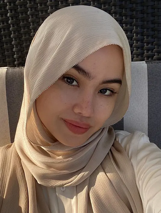 Masih dengan pashmina satin, kali ini, salah satu sisi pashmina direkatkan menggunakan jarum pentul ke samping kepala. Sementara sisi pashmina lainnya dibiarkan jatuh ke belakang. [@sashfir].