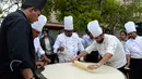 Koki India meratakan adonan saat membuat roti goreng Bhatura, India, New Delhi, Kamis (6/4). Penyelenggara berharap Bhatura buatan mereka bisa memecahkan rekor Bhatura  terbesar di India. (AFP PHOTO / SAJJAD HUSSAIN)