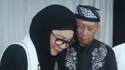 Bunda Iffet (kiri) saat memotong tumpeng pada acara ulang tahun suaminya markas slank, jakarta, senin (18/01/2016). Bimbim Slank juga membuat sebuah band keluarga pada perayaan ini yang bernama THE SIDHARTAS. (Liputan.com/Herman Zakharia)