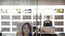 Seorang pegawai mengenakan masker menggunakan smartphone-nya ketika ia menunggu pelanggan di toko kacamata di pusat perbelanjaan di Beijing (28/1/2020).  Hingga Rabu (5/2/2020) pagi, jumlah pasien yang meninggal menjadi 479. (AP Photo/Mark Schiefelbein)
