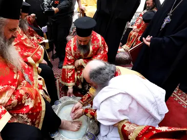 Patriark Teofilos III dari Yerusalem melakukan upacara cuci kaki tradisional di depan Gereja Makam Suci, Yerusalem (5/4). Ritual ini dilakukan setiap tahun pada Maundy atau Kamis Suci. (AFP Photo/Gali Tibbon)