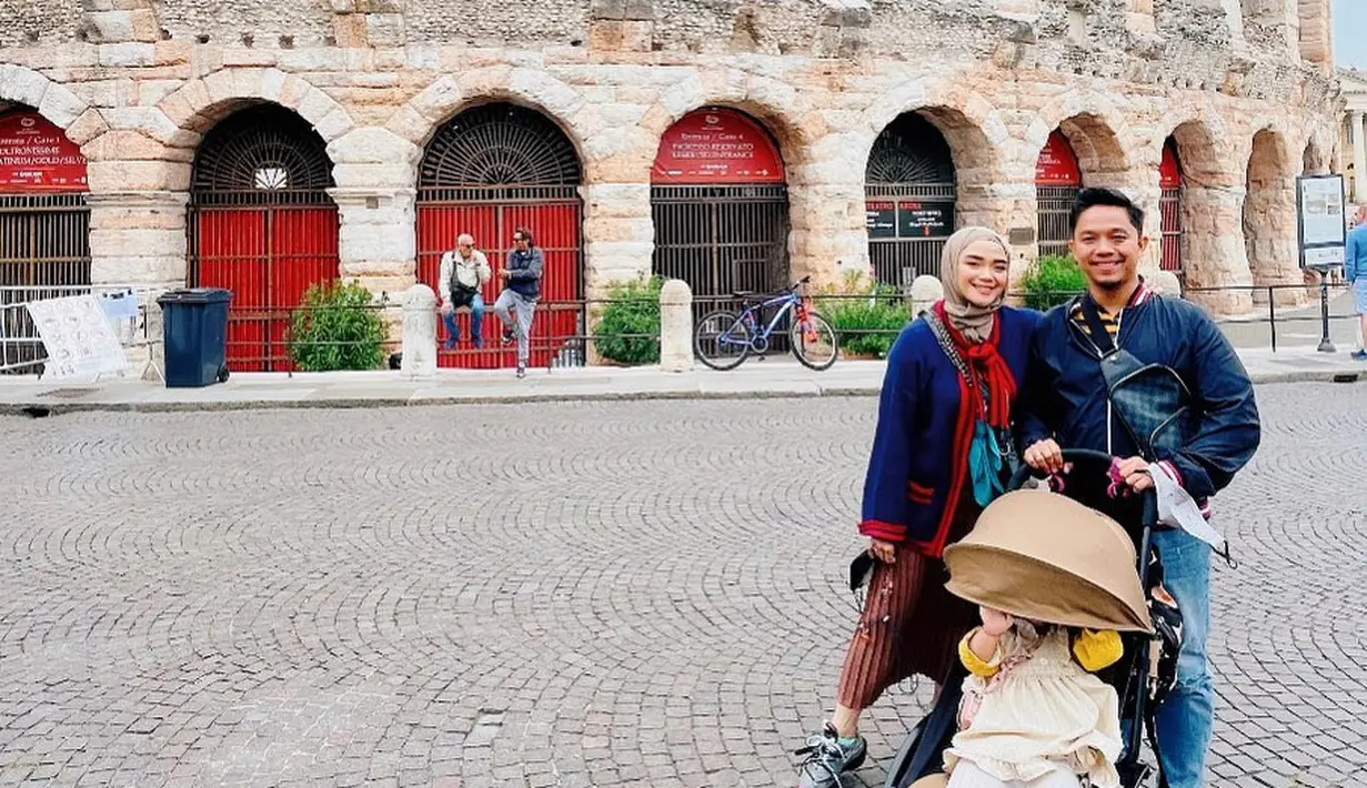 Mengabadikan momen bersama keluarga di Verona, Sheza Idris tampil dengan busana yang lebih gelap. Memadukan pleated skirt cokelat dengan tweed outer berwarna navy merah. (instagram/shezaidris)