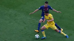 Pemain Barcelona, Sergio Busquets berebut bola dengan pemain Las Palmas, Hernan dalam pertandingan Liga Spanyol di Camp Nou, Senin (2/10) dini hari. Satu gol Busquets mewarnai kemenangan Barcelona3-0. (AP/Manu Fernandez)