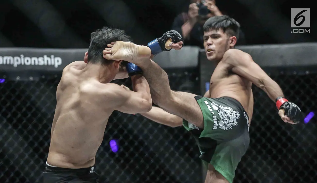 Dua petarung Indonesia, Rizki Umar (kanan) melakukan tendangan ke petarung Arnol Batubara (kiri) saat berlaga pada partai pertama dalam One Championship di Jakarta, Sabtu (20/1). Rizki Umar menang pada partai pertama. (Liputan6.com/Faizal Fanani)