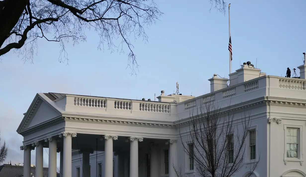 Bendera Amerika berkibar setengah tiang untuk menandai 500.000 kematian akibat Covid-19 di Gedung Putih pada Senin (22/2/2021). AS melewati tonggak yang mengejutkan dari 500.000 kematian covid-19 hanya lebih dari setahun setelah pandemi virus corona mengklaim korban pertama. (AP Photo/Evan Vucci)