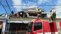 Petugas Pemadam Kebakaran Banyuwangi berjibaku memadamkan api yang membakar sebuah rumah di kawasan padat penduduk di Kelurahan Temengungan Banyuwangi (Hermawan Arifianto/Liputan6.com)