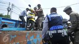 Petugas Dishub DKI melakukan penertiban parkir liar di kawasan Kebayoran Lama, Jakarta, Kamis (12/5). Razia dilakukan untuk menertibkan kawasan itu dan membuat jera pengendara yang memarkir kendaraan bukan pada tempatnya. (Liputan6.com/Gempur M Surya)
