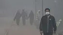 Orang-orang berjalan di sekitar taman di tengah kondisi kabut asap tebal di Lahore pada Kamis 7 November 2024. (Arif ALI/AFP)