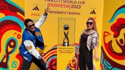 Musisi Ridwan Naibaho (kiri) dan Lilis Darawangi berpose bersama trofi Piala Dunia u-17 2023 alam acara Trophy Experience yang berlangsung di Balai Pemuda Surabaya, Minggu (29/10/2023). (Dok. SCM)