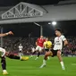 Gelandang Manchester United (MU) Bruno Fernandes  mengumpan bola ketika bek Fulham Antonee Robinson mencoba untuk memblokir pada pekan ke-16 Liga Inggris 2022/2023 di Craven Cottage, London, Minggu (13/11/2022). Kemenangan ini menjaga jarak Man United dengan empat besar. (Photo by Glyn KIRK / AFP)