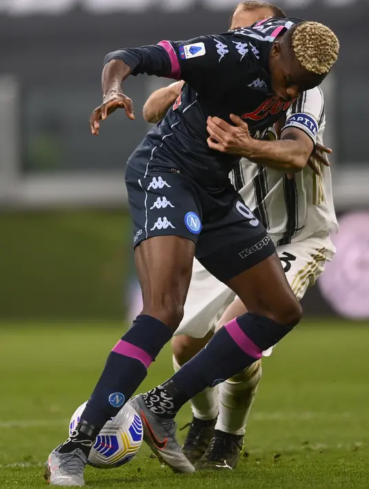Penyerang Napoli, Victor Osimhen berebut bola dengan bek Juventus, Giorgio Chiellini pada laga tunda pekan ketiga Serie A di Allianz Stadium, Kamis (8/4/2021) dini hari WIB. Juventus menang 2-1 atas Napoli lewat gol yang dicetak Ronaldo dan Dybala.  (Fabio Ferrari/LaPresse via AP)