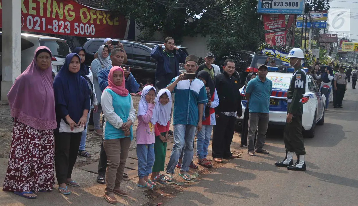 Warga sekitar Puri Cikeas bersiap menyambut iring-iringan kepergian jenazah Ani Yudhoyono menuju TMP Kalibata, Bogor, Jawa Barat, Minggu (2/6/2019). Ani Yudhoyono dimakamkan secara militer. (Liputan6.com/Immanuel Antonius)