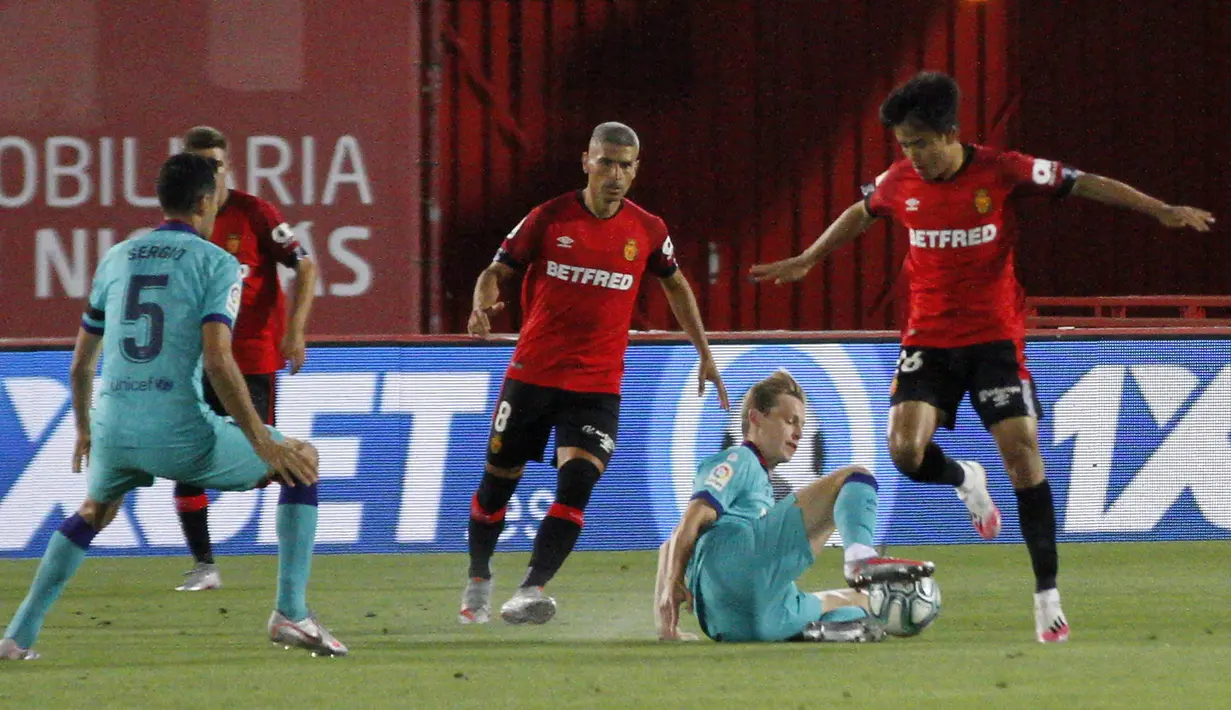 Pemain Marllorca Kubo (kanan) mencoba melewati pemain Barcelona Frenkie de Jong pada pertandingan La Liga di Son Moix Stadium, Palma de Mallorca, Spanyol, Sabtu (13/6/2020). Barcelona membantai Mallorca dengan skor 4-0. (AP Photo/Francisco Ubilla)