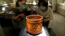 Pengunjung mengamati benda yang dipajang dalam pameran keramik di Zhengzhou, Provinsi Henan, China, 25 Agustus 2020. Pameran keramik tersebut dimulai di Zhengzhou pada Selasa (25/8) dengan menampilkan 100 lebih benda dari zaman kuno yang ditemukan di sepanjang cekungan Sungai Kuning. (Xinhua/Li An)