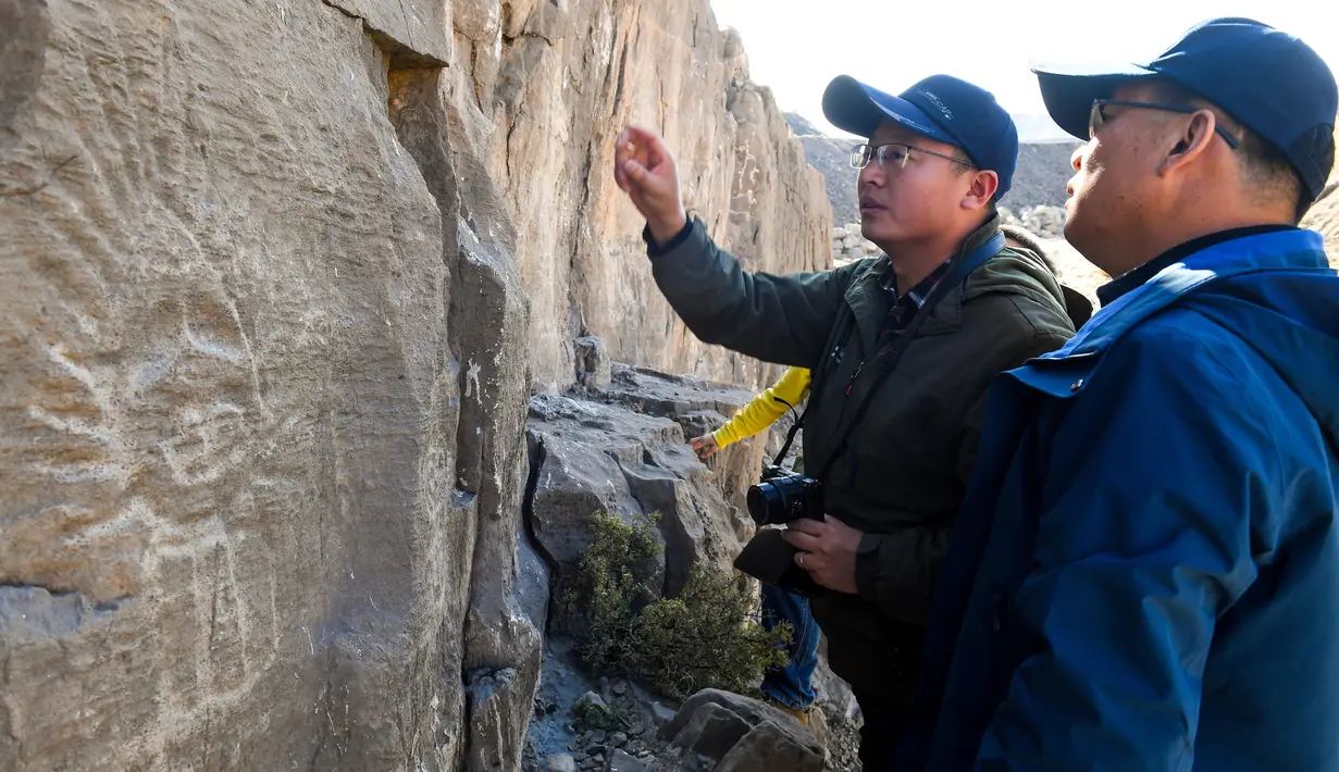 Para arkeolog mempelajari lukisan batu di klaster seni cadas Gunung Zhuozi di Daerah Otonom Mongolia Dalam, China pada 17 Oktober 2020. Gunung Zhuozi adalah tempat dengan banyak lukisan batu yang berguna untuk penelitian tentang asal muasal nomad kuno di China. (Xinhua/Peng Yuan)