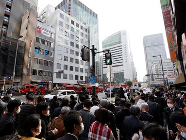 Mobil pemadam kebakaran terlihat di depan sebuah gedung, tempat kebakaran terjadi di Osaka (17/12/2021). Puluhan orang dikhawatirkan tewas setelah kebakaran di sebuah gedung komersial di Jepang barat. (AFP/STR/Jiji Pers)