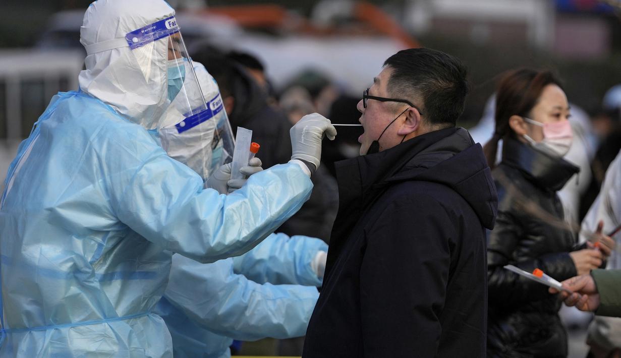 Seorang pria mendapatkan usap tenggorokan untuk tes COVID-19 di fasilitas pengujian virus corona seluler di Beijing, Senin (17/1/2022). Beijing telah melaporkan infeksi omicron lokal pertamanya, beberapa minggu sebelum Olimpiade Musim Dingin akan dimulai. (AP Photo/Andy Wong)