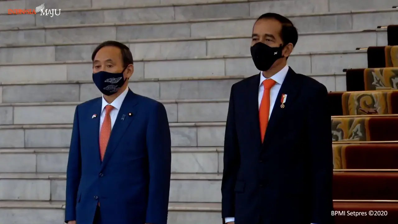 PM Suga bersama dengan Presiden Jokowi mengikuti prosesi upacara penyambutan.