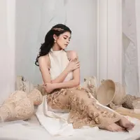 Rambutnya ditata bergaya half updo, dipermanis dengan aksesori rambut berbentuk dedaunan warna emas. [@jharnabhagwani]