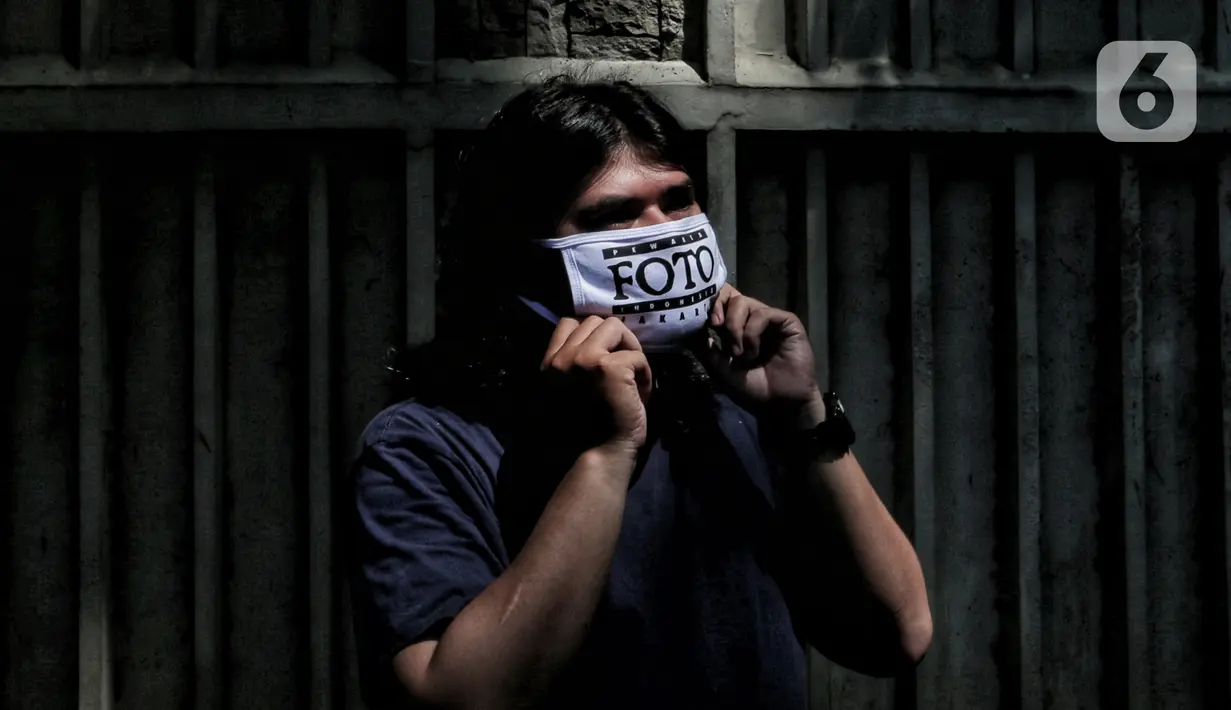 Anggota Pewarta Foto Indonesia Jakarta (PFIJ) memakai masker penunjang liputan di Jakarta, Rabu (22/4/2020). PFIJ membagikan 230 paket penunjang liputan berupa masker, hand sanitizer, dan multivitamin kepada anggotanya yang melaksanakan tugas jurnalistik selama pandemi. (Liputan6.com/Johan Tallo)