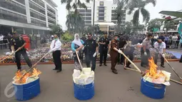 Petugas membakar barang hasil sitaan di Kantor Pusat Bea Cukai, Jakarta, Senin (20/6). Bea Cukai memusnahkan botol miras ilegal, pita cukai MMEA impor palsu, hasil tembakau serta barang larangan dan pembatasan kiriman pos. (Liputan6.com/Immanuel Antonius)