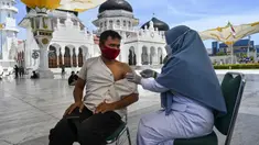 Seorang pria menerima dosis vaksin virus corona COVID-19 Moderna saat pelaksanaan vaksinasi di Masjid Raya Baiturrahman, Banda Aceh, Aceh, Selasa (7/9/2021). (CHAIDEER MAHYUDDIN/AFP)