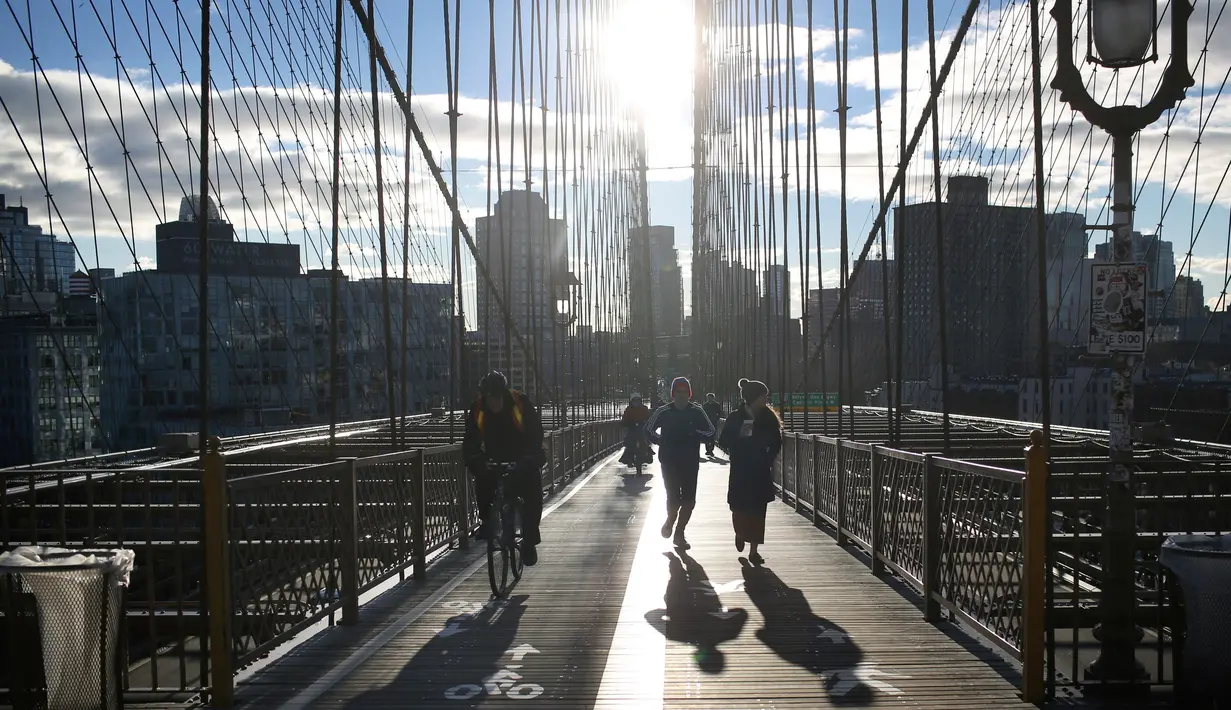 Orang-orang beraktivitas melintasi Jembatan Brooklyn di New York, 4 Desember 2018. Sempat diberi nama Jembatan Sungai Timur, Jembatan New York dan Brooklyn, akhirnya pada 1915 berubah menjadi Jembatan Brooklyn hingga sekarang. (AP /Wong Maye-E)