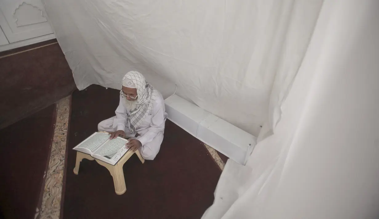 <p>Seorang Umat Muslim membaca al-Quran saat melakukan ibadah itikaf di sebuah masjid, di Peshawar , Pakistan, 22 April 2022. Itikaf adalah adalah tinggal atau menetap di dalam masjid dengan niat beribadah untuk mendekatkan diri kepada Allah pada sepuluh hari terakhir Ramadhan. (AP Photo/Muhammad Sajjad)</p>
