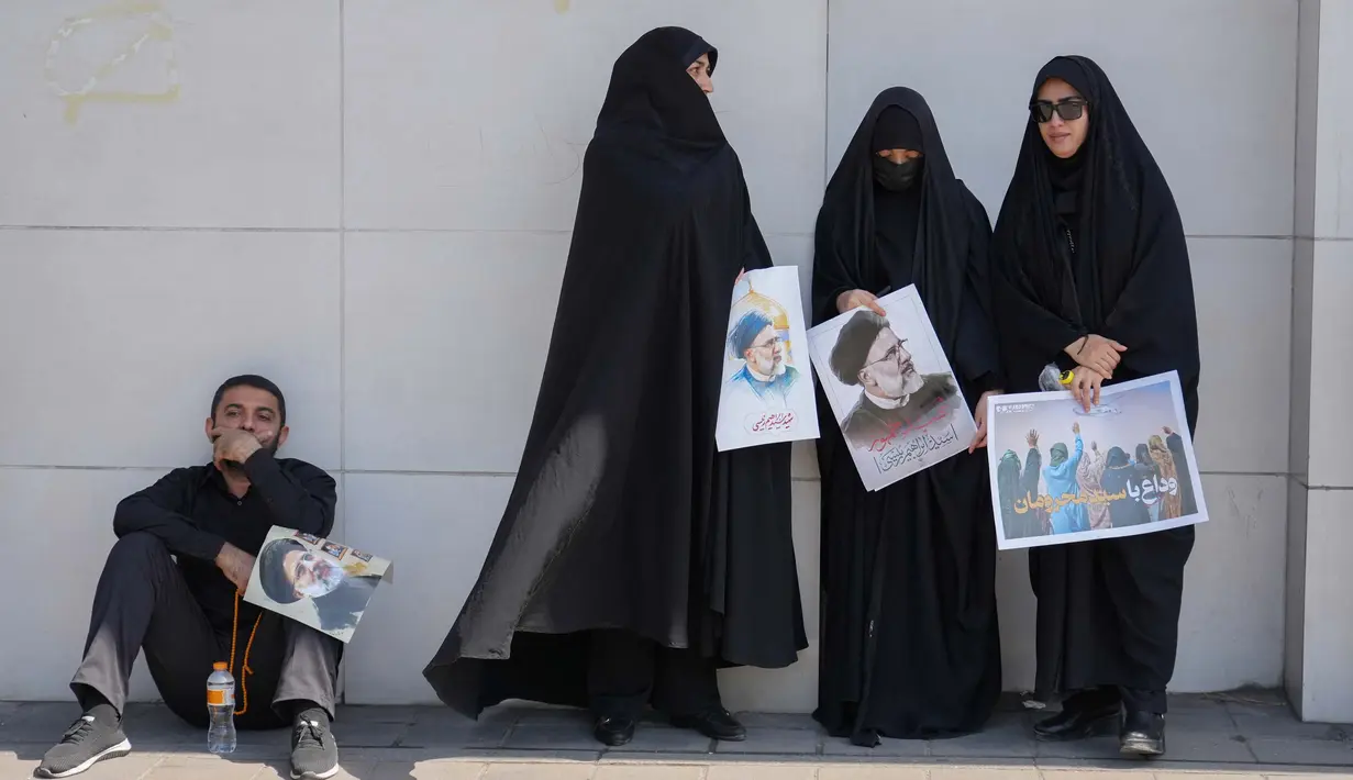 Sejumlah warga hadir dengan membawa gambar dan foto Presiden Ebrahim Raisi. (Foto: AFP)