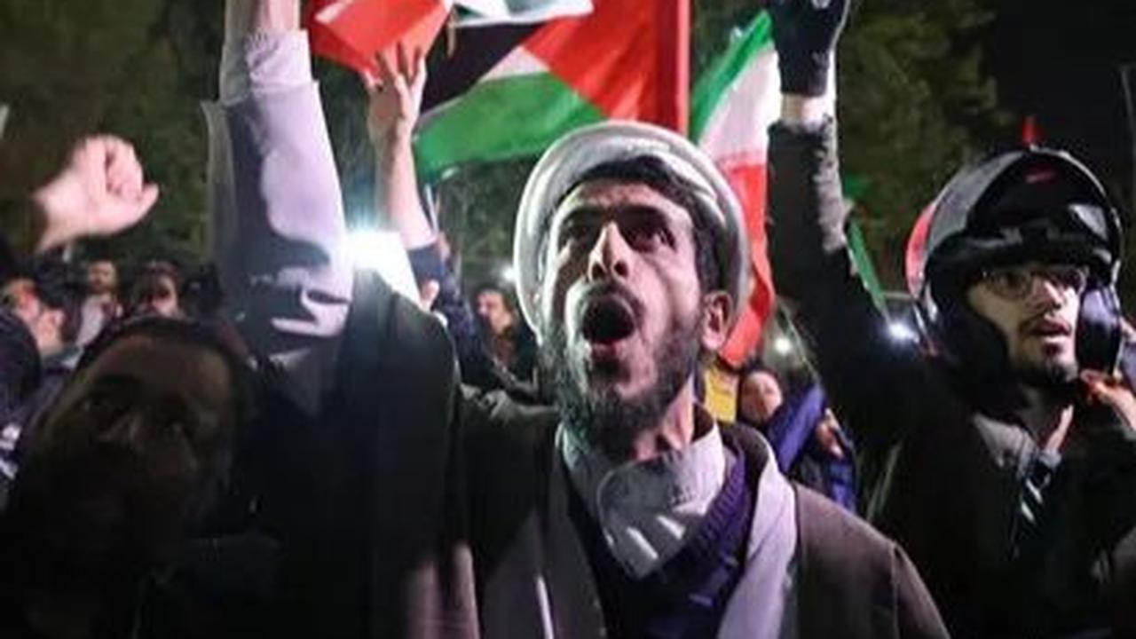 Sejumlah pengunjuk rasa turun ke jalan dengan mengibarkan bendera kenegaraan di depan Kedutaan Besar Inggris, Teheran, Iran, Minggu (14/4/2024). Dalam aksinya, mereka menyuarakan dukungan atas serangan ratusan drone dan rudal yang ditembakkan Iran terhada
